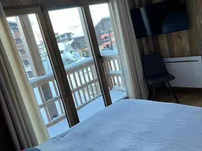 a bedroom with a bed and a view of a balcony at Appartement moderne en centre-ville avec parking et animaux admis - 6 pers. - FR-1-836-49 in Arâches-la-Frasse