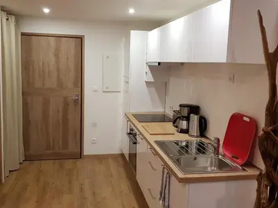 a kitchen with white cabinets and a sink and a door at Appartement moderne en centre-ville avec parking et animaux admis - 6 pers. - FR-1-836-49 in Arâches-la-Frasse