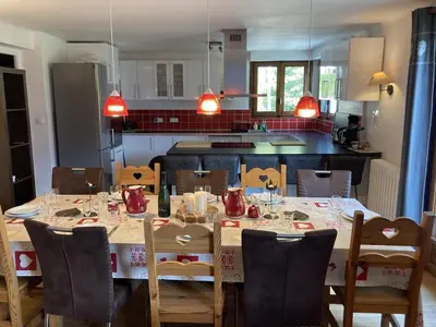 a dining room with a table and a kitchen at Chalet cosy 6 chambres, 14 pers, proche télécabine, parking, non fumeur - FR-1-836-28 in Arâches-la-Frasse