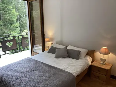 a bedroom with a bed and a large window at Chalet cosy 6 chambres, 14 pers, proche télécabine, parking, non fumeur - FR-1-836-28 in Arâches-la-Frasse