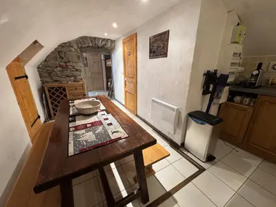 a kitchen with a wooden table and a refrigerator at Appartement de charme dans chalet rénové - Animaux et parking - FR-1-836-54 in Arâches-la-Frasse