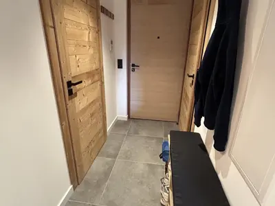 a hallway with a door and a bench in a room at Nouveau ! Appartement de standing 3 chambres avec balcon et parking couvert - FR-1-836-42 in Arâches-la-Frasse