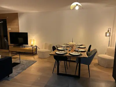 a living room with a table and chairs and a television at Nouveau ! Appartement de standing 3 chambres avec balcon et parking couvert - FR-1-836-42 in Arâches-la-Frasse