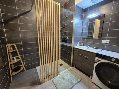 a bathroom with a washing machine and a sink at Appartement neuf 2 chambres avec parking, rez-de-jardin - FR-1-836-52 in Arâches-la-Frasse