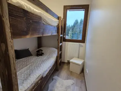 a bedroom with two bunk beds with a teddy bear on it at Appartement neuf 2 chambres avec parking, rez-de-jardin - FR-1-836-52 in Arâches-la-Frasse