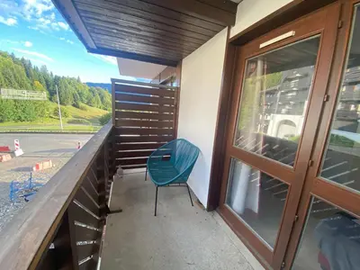 a balcony with a blue chair and a window at Studio à Morillon pour 4 pers. proche pistes et commerces - FR-1-815-105 in Morillon