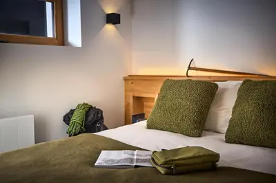 a bed with a book and a bag on it at Chalet Juno - Chamonix All Year in Chamonix-Mont-Blanc