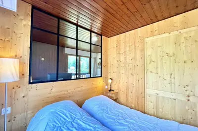a bedroom with a bed in a wooden wall at Superb apartment in Megève in Megève