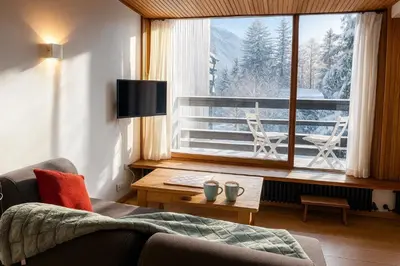a living room with a couch and a large window at Bright apartment for 6 people in Chamonix in Chamonix-Mont-Blanc