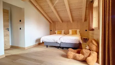 a bedroom with a bed and a chair and a window at Chalet des Pres- 3 chambres - JAILLET - in Demi-Quartier