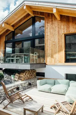 a house with a deck with a couch and chairs at New Chalet Facing The Aiguilles De Chamonix in Les Houches