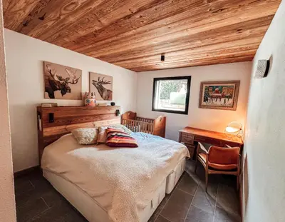 a bedroom with a bed and a wooden ceiling at New Chalet Facing The Aiguilles De Chamonix in Les Houches