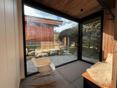 a room with a chair and a large window at New Chalet Facing The Aiguilles De Chamonix in Les Houches