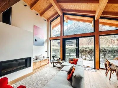 a living room with a couch and a large window at New Chalet Facing The Aiguilles De Chamonix in Les Houches