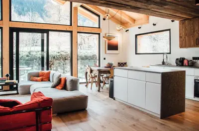 a kitchen and living room with a couch and a table at New Chalet Facing The Aiguilles De Chamonix in Les Houches