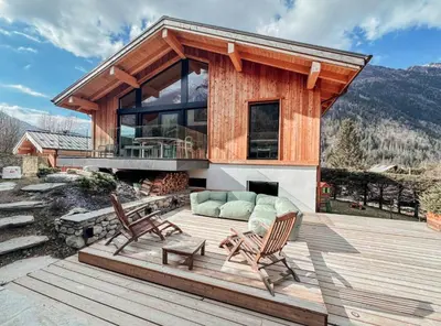 a house with two chairs and a couch on a deck at New Chalet Facing The Aiguilles De Chamonix in Les Houches