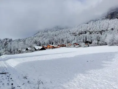 a snow covered field with houses in a mountain at La Tanière des Cimes, sauna privé in Passy
