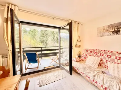 a bedroom with a sliding glass door leading to a balcony at Le Gemma in Saint-Gervais-les-Bains