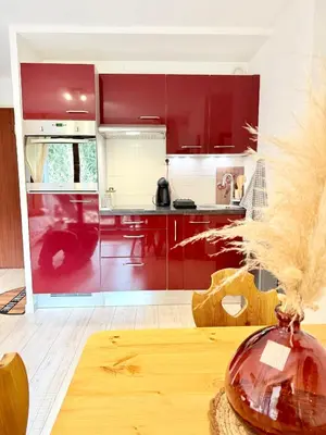 a kitchen with red cabinets and a wooden table at Le Gemma in Saint-Gervais-les-Bains