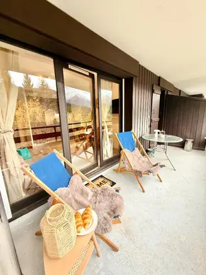 a room with two chairs and a table and a balcony at Le Gemma in Saint-Gervais-les-Bains