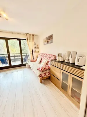 a room with a bed and a kitchen with windows at Le Gemma in Saint-Gervais-les-Bains