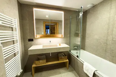 a bathroom with a sink and a tub and a mirror at Apartment with garden and proximity to activities in Chamonix-Mont-Blanc