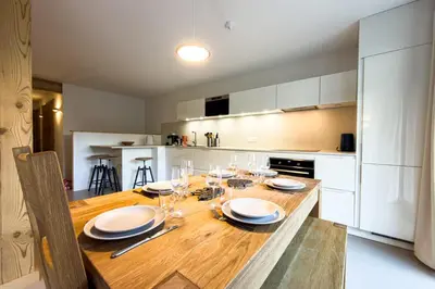 a kitchen with a wooden table with plates and wine glasses at Apartment with garden and proximity to activities in Chamonix-Mont-Blanc
