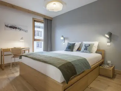 a bedroom with a large bed and a desk at White Dream - Vue et confort en centre-ville in Chamonix-Mont-Blanc