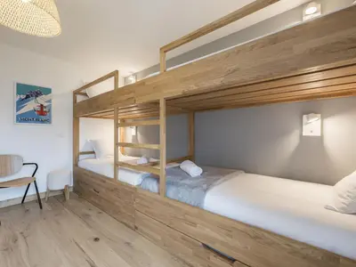 two bunk beds in a room with a desk at White Dream - Vue et confort en centre-ville in Chamonix-Mont-Blanc