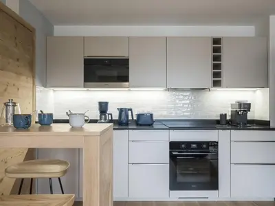 a kitchen with white cabinets and a stove top oven at White Dream - Vue et confort en centre-ville in Chamonix-Mont-Blanc