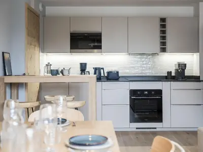 a kitchen with white cabinets and a table with chairs at White Dream - Vue et confort en centre-ville in Chamonix-Mont-Blanc