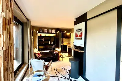 a living room with a couch and a window at Bright apartment with balcony and pool in Megève