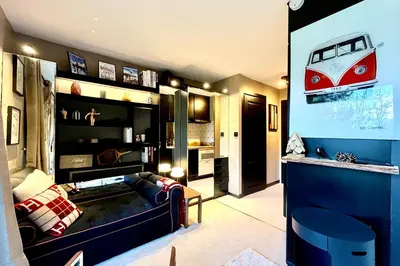 a living room with a couch and a red car on the wall at Bright apartment with balcony and pool in Megève