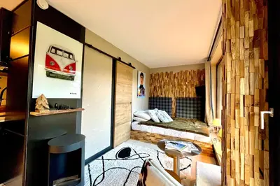a small room with a bed and a tv in it at Bright apartment with balcony and pool in Megève