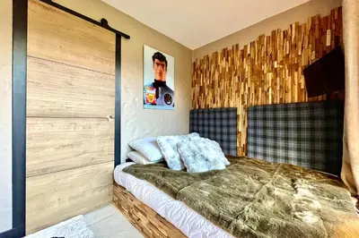 a bedroom with a bed and a wooden door at Bright apartment with balcony and pool in Megève