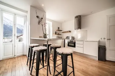 a kitchen with a counter and stools in it at Apartment Brina Chamonix - by EMERALD STAY in Chamonix-Mont-Blanc
