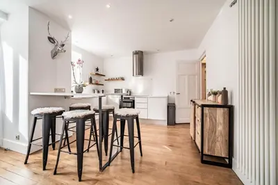 a kitchen with bar stools and a kitchen with white cabinets at Apartment Brina Chamonix - by EMERALD STAY in Chamonix-Mont-Blanc