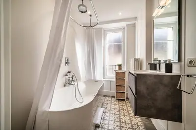 a white bathroom with a tub and a sink and a tub at Apartment Brina Chamonix - by EMERALD STAY in Chamonix-Mont-Blanc