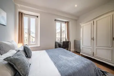 a bedroom with a bed and two windows at Apartment Brina Chamonix - by EMERALD STAY in Chamonix-Mont-Blanc