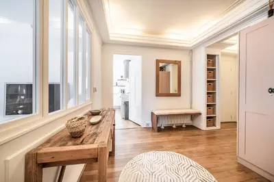 a living room with a wooden table and some windows at Apartment Brina Chamonix - by EMERALD STAY in Chamonix-Mont-Blanc