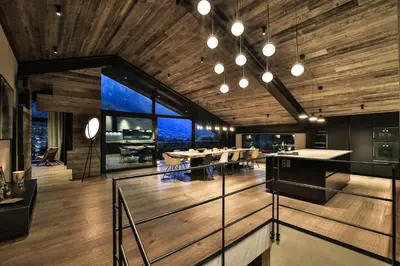 a room with wooden ceilings and a dining room with tables at Chalet onthe Rocks in Chamonix-Mont-Blanc
