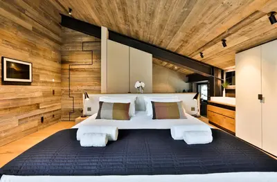 a bedroom with a large bed and wooden walls at Chalet onthe Rocks in Chamonix-Mont-Blanc