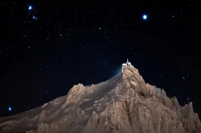 a mountain with a lighthouse on top of it at night at Chalet onthe Rocks in Chamonix-Mont-Blanc