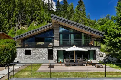 a house with an umbrella in front of it at Chalet onthe Rocks in Chamonix-Mont-Blanc