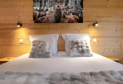 a bed with two pillows and a picture of deer at Cozy Sleeps 4 Mountain view 300m lift in Chamonix-Mont-Blanc