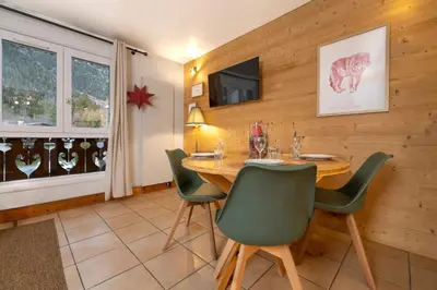 a dining room with a table and chairs at Cozy Sleeps 4 Mountain view 300m lift in Chamonix-Mont-Blanc