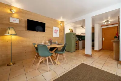 a dining room with a table and a green refrigerator at Cozy Sleeps 4 Mountain view 300m lift in Chamonix-Mont-Blanc