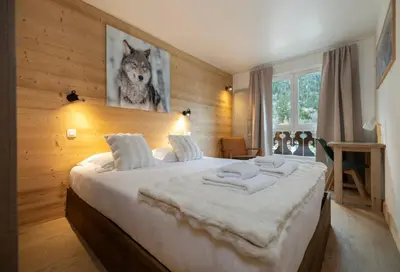 a bedroom with a large bed with a wolf picture on the wall at Cozy Sleeps 4 Mountain view 300m lift in Chamonix-Mont-Blanc