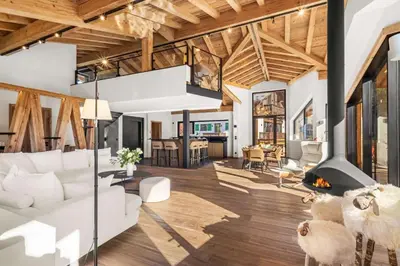 a living room with a white couch and a fireplace at Chalet Rémond - Vue Montagnes in Chamonix-Mont-Blanc