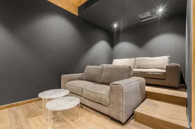 a living room with a couch and two stools at Chalet Rémond - Vue Montagnes in Chamonix-Mont-Blanc
